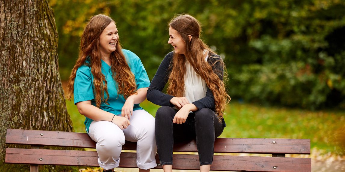 Pfleger und Patient lachen im Freien