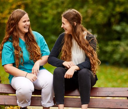 Pfleger und Patient lachen im Freien Ausbildung im MEDICLIN Reha-Zentrum Gernsbach